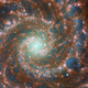 The spiral galaxy is a whirlpool of brown, blue, and pink.